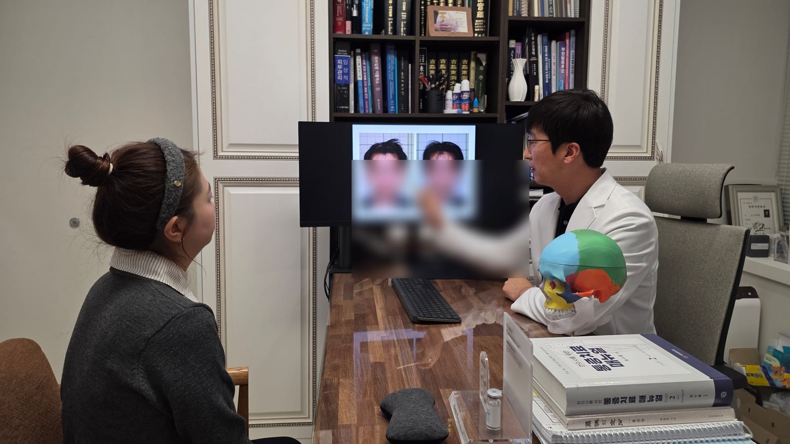 울산 정한의원 진료실에서 두개골 모형과 사진 자료로 안면비대칭 검사 결과를 설명하는 모습
