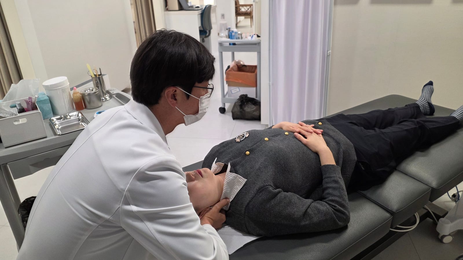 울산 정한의원에서 정석환 원장이 누워 있는 환자의 턱과 목을 추나요법으로 교정하는 모습